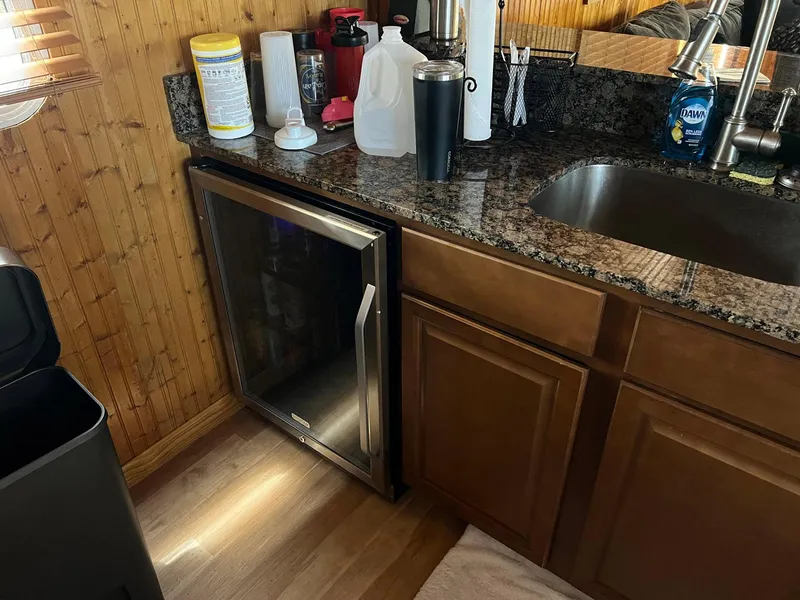 Slide: The Image of Kitchen area in a 1989 Sumerset Houseboat, featuring granite countertop and mini fridge. - 6