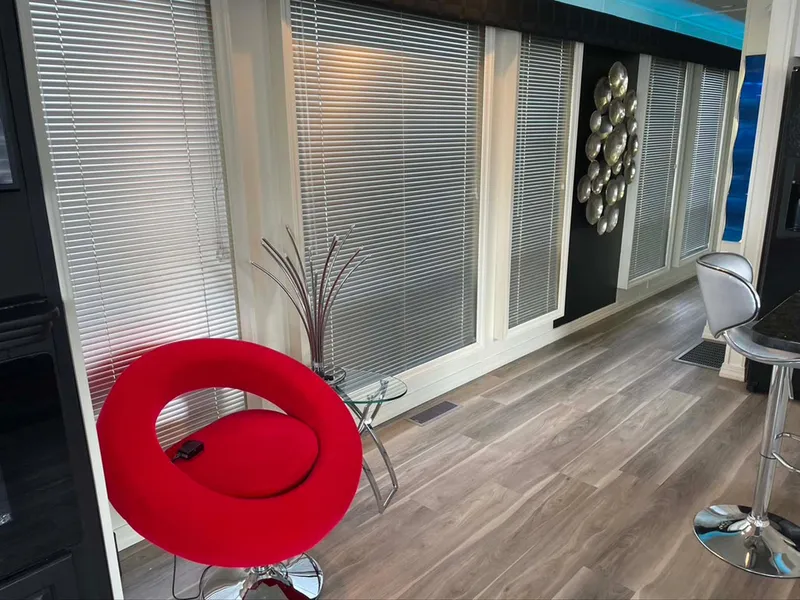 Slide: The Image of Modern interior with red chair, blinds, and decorative wall art in a Thoroughbred 6516 model. - 18