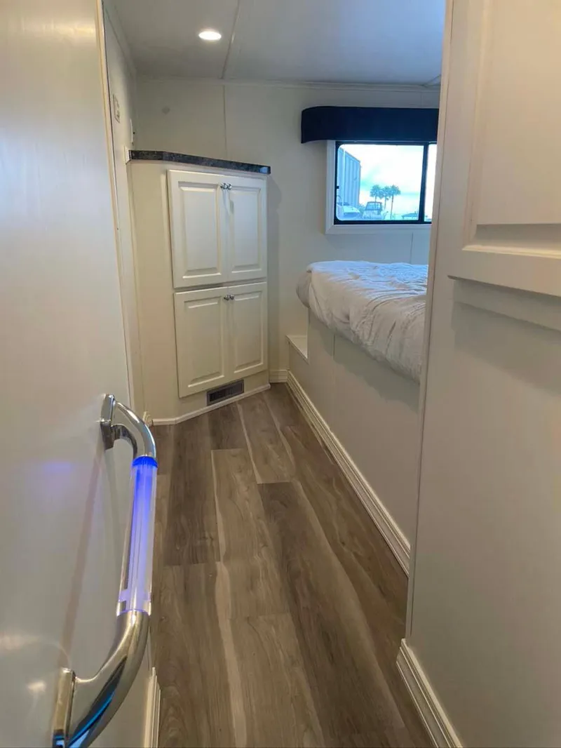 Slide: The Image of Interior of 2004 Thoroughbred 6516 RV with modern wood flooring and cozy bedroom. - 22