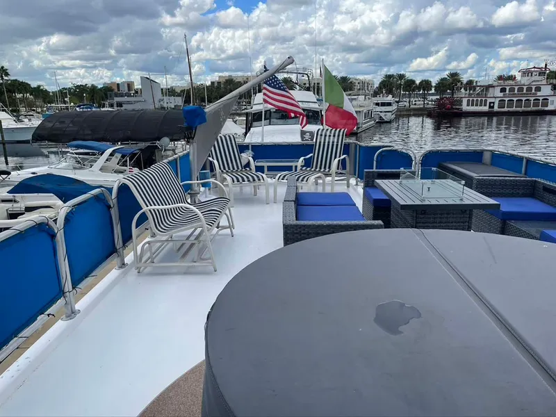 Slide: The Image of Upper deck of 2004 Thoroughbred 6516 yacht with seating, flags, and marina view. - 26