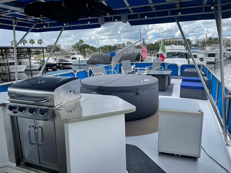 Slide: The Image of Luxurious 2004 Thoroughbred 6516 yacht deck with grill, hot tub, and seating area in marina. - 27