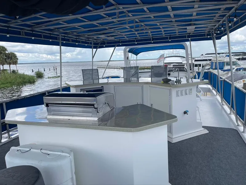 Slide: The Image of Outdoor deck of 2004 Thoroughbred 6516 boat with seating and grill, overlooking water. - 29