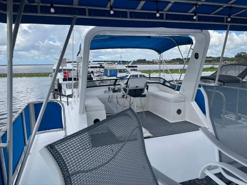 Slide: The Image of 2004 Thoroughbred 6516 boat with blue canopy, docked on a calm lake. - 30