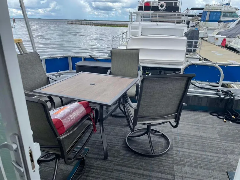 Slide: The Image of Outdoor seating on a 2004 Thoroughbred 6516 boat, docked by a calm waterfront. - 31