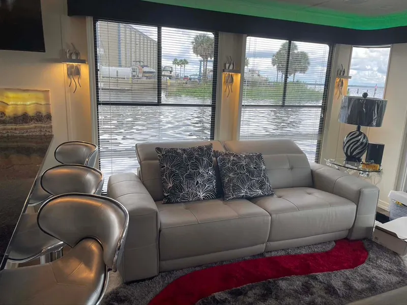 Slide: The Image of Luxurious 2004 Thoroughbred 6516 interior with modern decor, leather sofa, and scenic window view. - 5