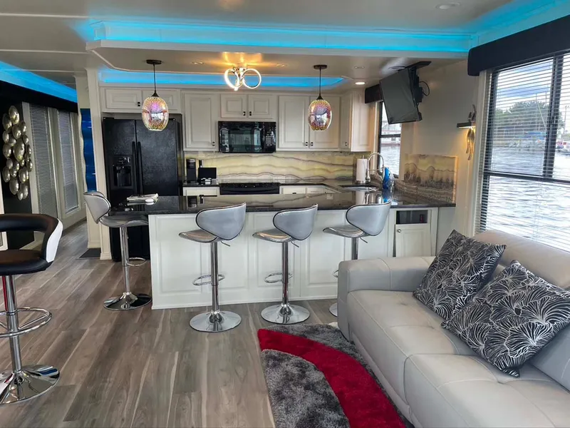 Slide: The Image of Luxurious houseboat interior with modern kitchen, bar stools, and cozy living area, Thoroughbred 6516, 2004. - 6
