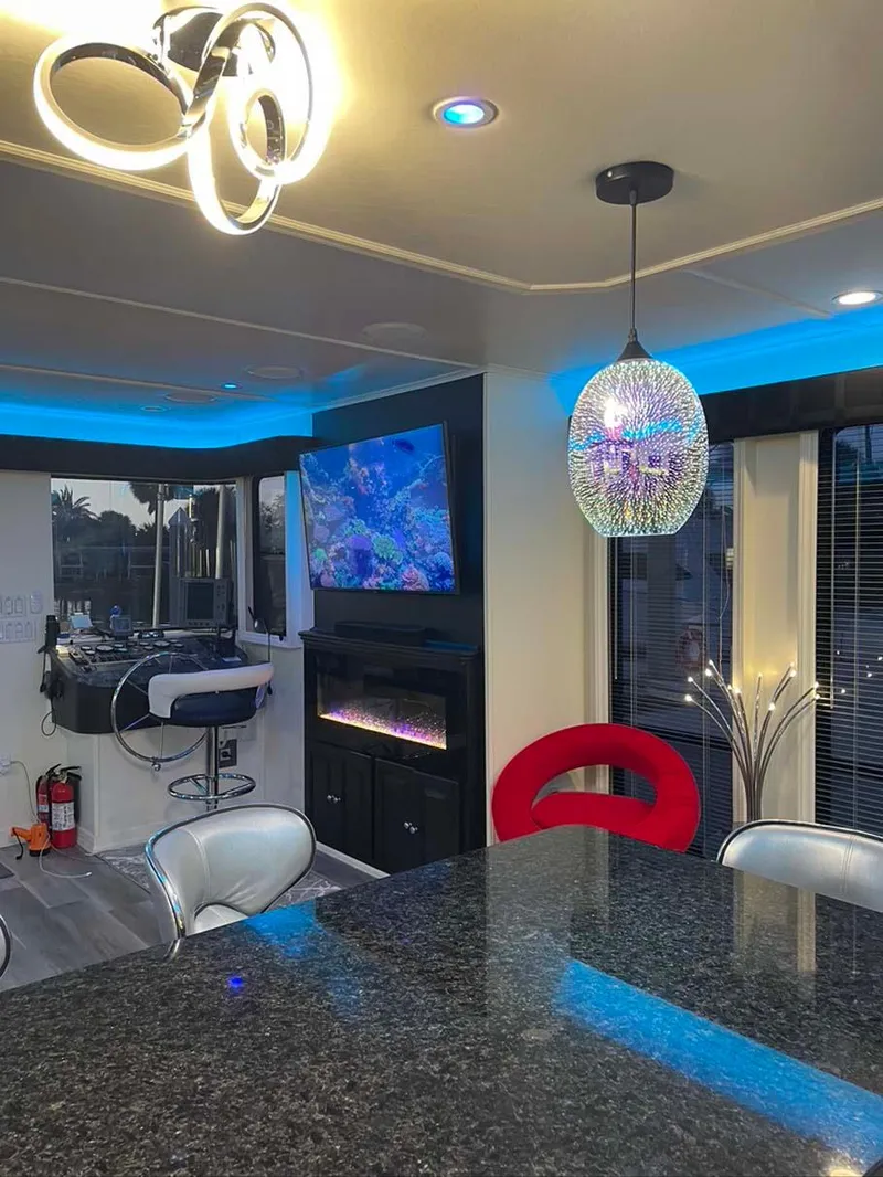 Slide: The Image of Modern kitchen interior with granite countertop, stylish lighting, and a mounted TV in a Thoroughbred 6516, 2004. - 9