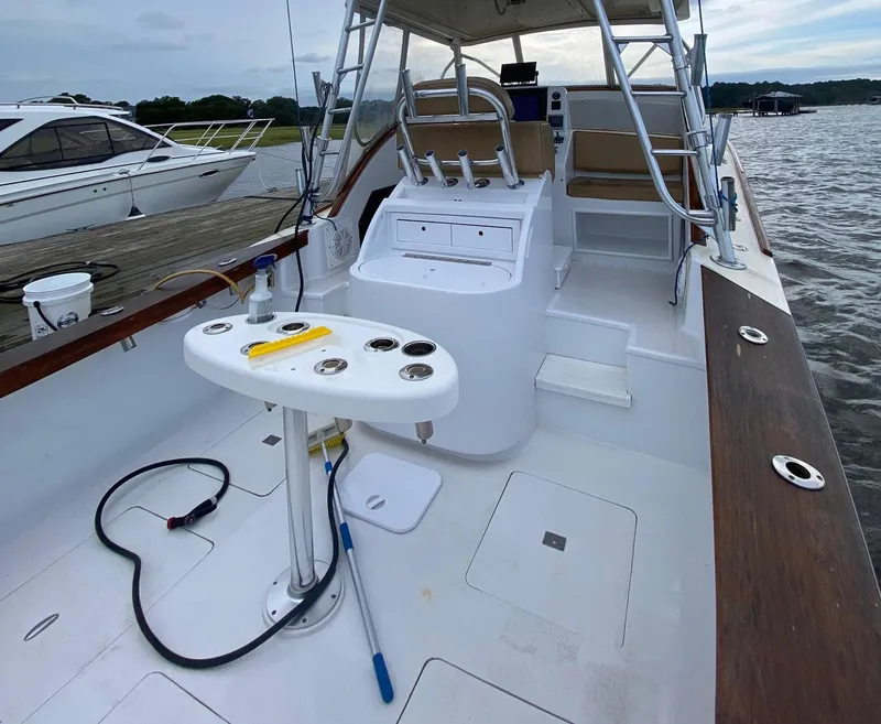 Slide: The Image of Custom Stardust 32 Express 2005 boat interior with fishing setup and seating, docked by the water. - 17