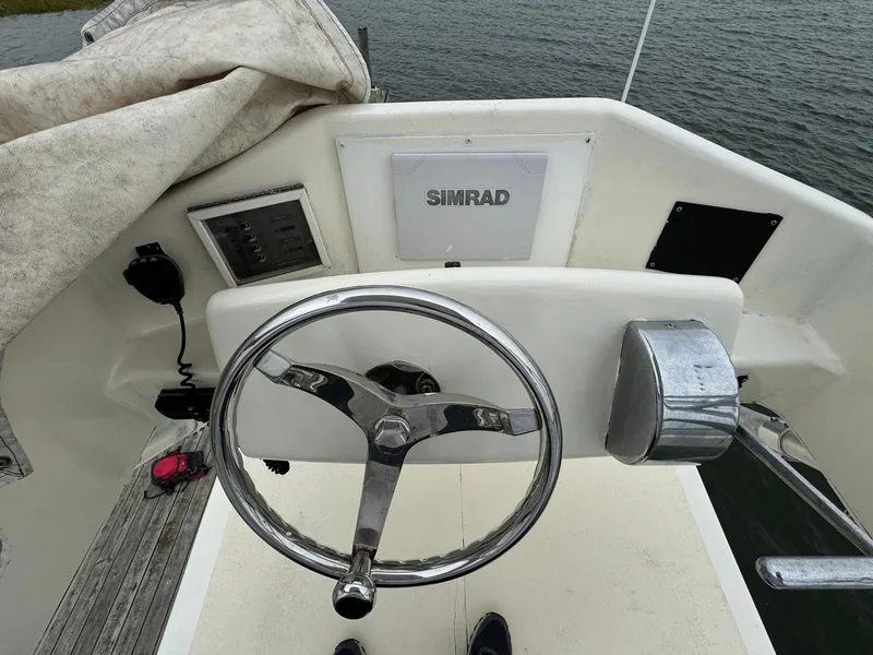 Slide: The Image of Steering wheel and controls of a 2005 Custom Stardust 32 Express boat. - 18