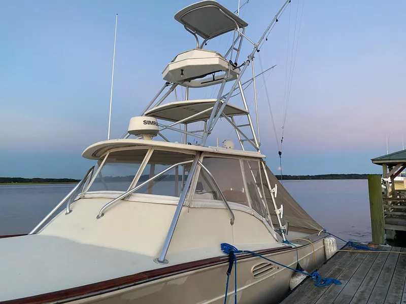 Slide: The Image of Custom Stardust 32 Express 2005 boat docked by calm waters at sunset. - 4