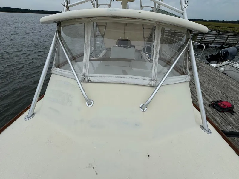 Slide: The Image of 2005 Custom Stardust 32 Express boat docked by the water. - 8