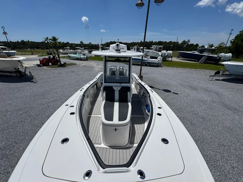 Slide: The Image of 2023 Tidewater 282 CC Adventure Bluewater boat in a marina under a clear sky. - 22