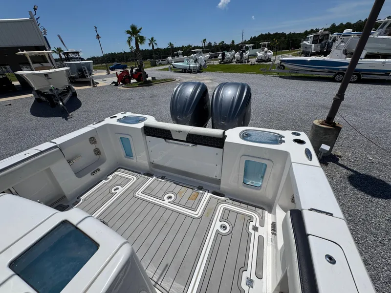 Slide: The Image of 2023 Tidewater 282 CC Adventure Bluewater boat interior with dual engines, docked outdoors. - 39