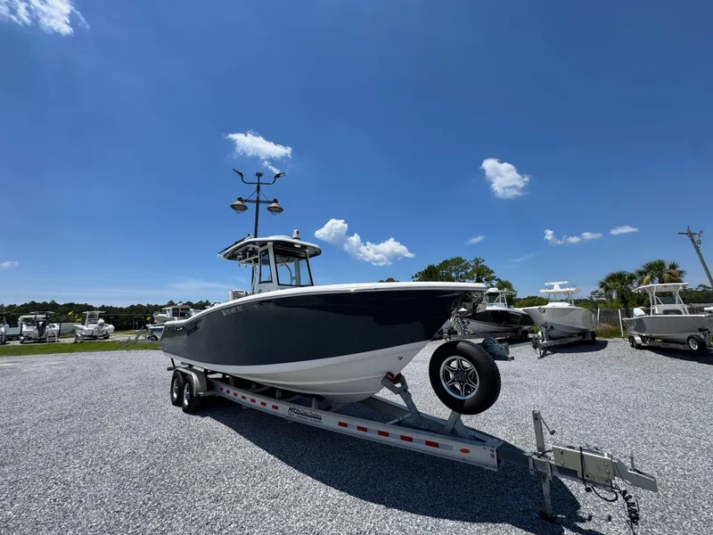 Slide: The Image of 2023 Tidewater 282 CC Adventure Bluewater boat on trailer under clear blue sky. - 4