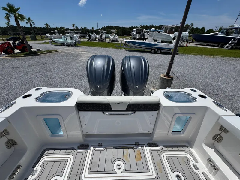 Slide: The Image of 2023 Tidewater 282 CC Adventure Bluewater boat with dual engines, docked in a marina. - 40
