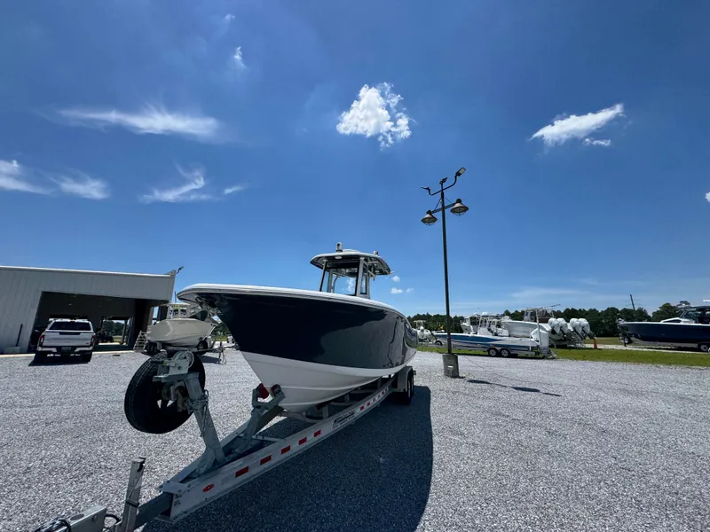 Slide: The Image of 2023 Tidewater 282 CC Adventure Bluewater boat on trailer under clear blue sky. - 7