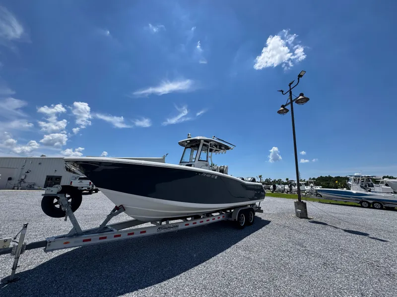 Slide: The Image of 2023 Tidewater 282 CC Adventure Bluewater boat on trailer under clear blue sky. - 8