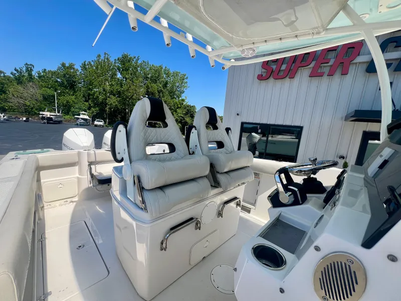 Slide: The Image of 2023 Sailfish 290 CC boat interior with dual seats and steering console. - 14