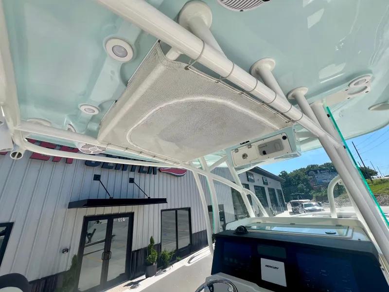 Slide: The Image of 2023 Sailfish 290 CC boat interior with electronics and overhead storage. - 15