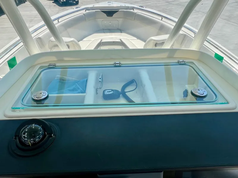 Slide: The Image of 2023 Sailfish 290 CC boat dashboard with compass and storage compartment. - 22