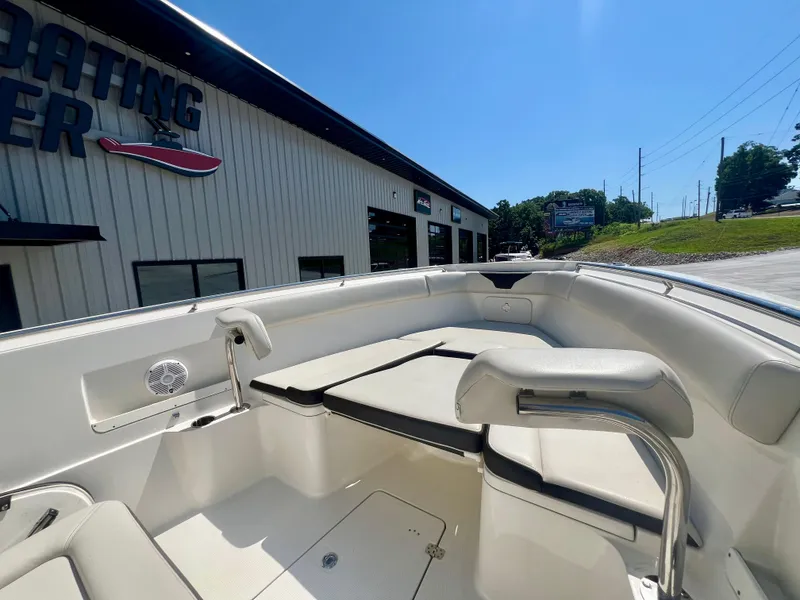 Slide: The Image of 2023 Sailfish 290 CC boat interior at a dealership under clear blue sky. - 26