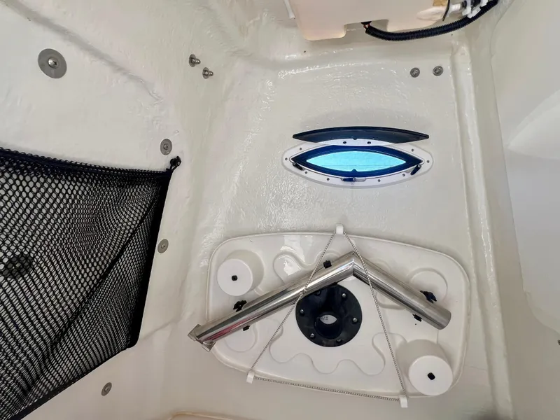 Slide: The Image of Interior view of 2023 Sailfish 290 CC boat, featuring a storage net and porthole window. - 32