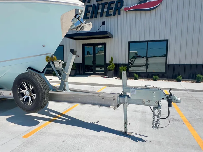 Slide: The Image of 2023 Sailfish 290 CC boat on trailer outside a marine center. - 35