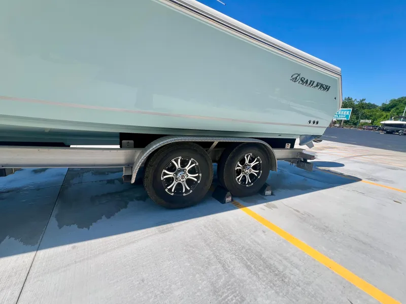 Slide: The Image of 2023 Sailfish 290 CC boat on trailer, parked in sunny lot. - 36