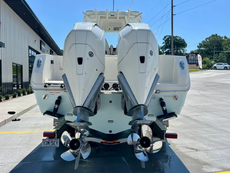 Slide: The Image of 2023 Sailfish 290 CC boat with dual outboard engines, parked outdoors. - 37