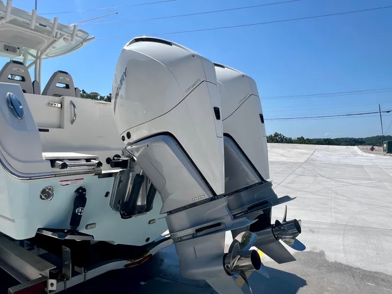 Slide: The Image of 2023 Sailfish 290 CC boat with dual outboard engines on a trailer. - 38