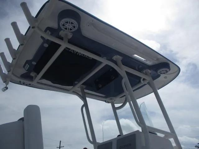 Slide: The Image of 2025 Caymas 26HB boat T-top with speakers and rod holders against cloudy sky. - 7