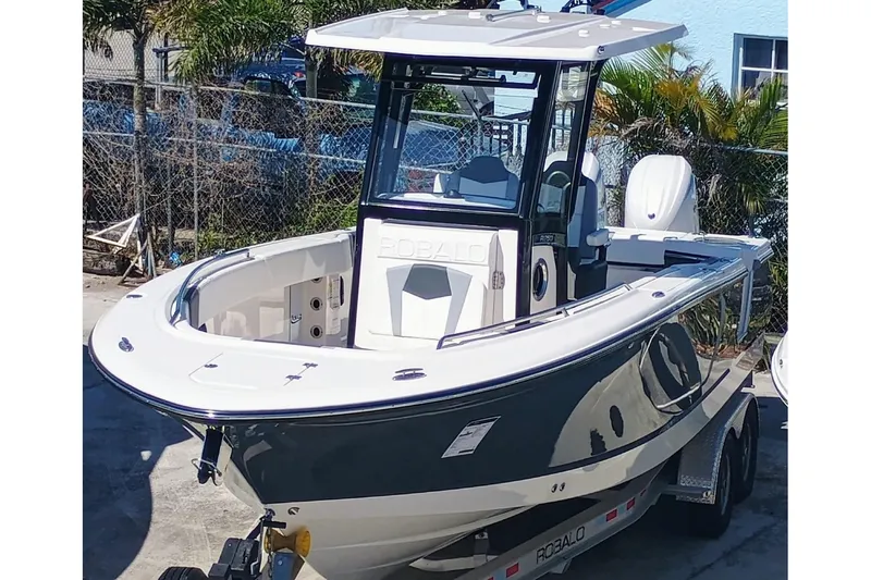 Slide: The Image of 2024 Robalo R250 Center Console boat on trailer, parked outdoors. - 1