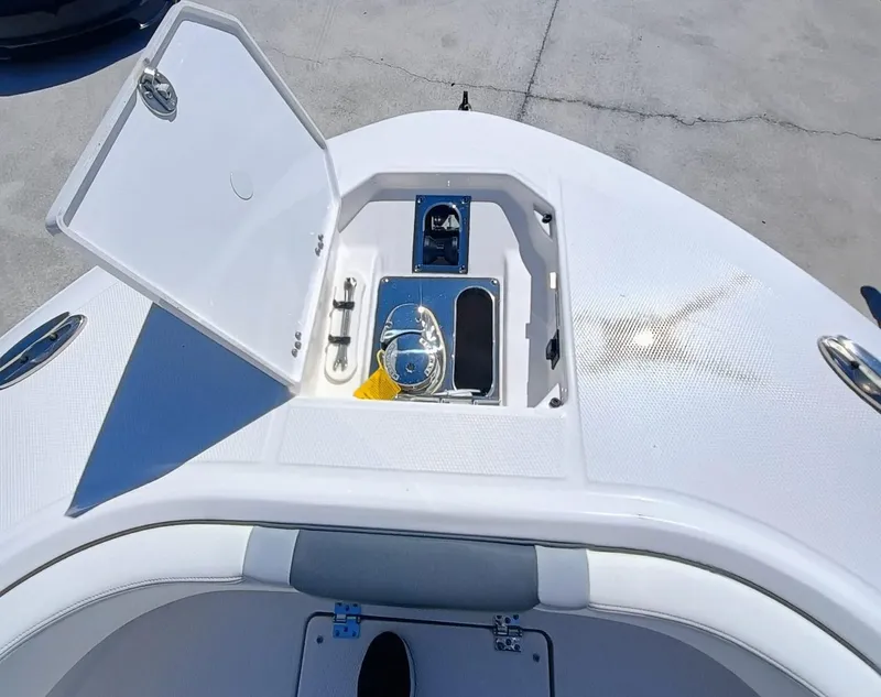 Slide: The Image of 2024 Robalo R250 Center Console boat anchor storage compartment open on deck. - 24