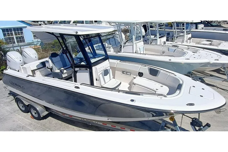 Slide: The Image of 2024 Robalo R250 Center Console boat on trailer, featuring sleek design and dual engines. - 3