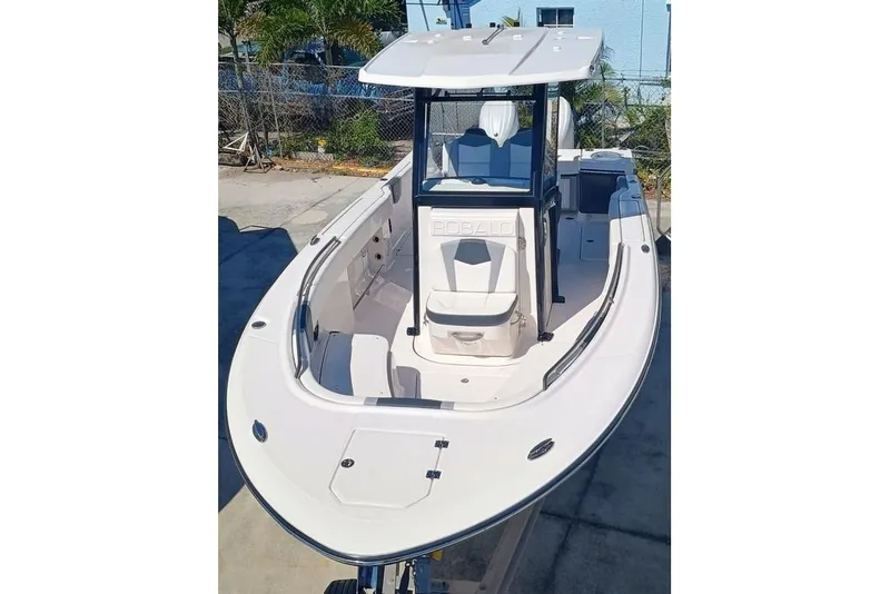 Slide: The Image of 2024 Robalo R250 Center Console boat, docked, showcasing spacious deck and modern design. - 5