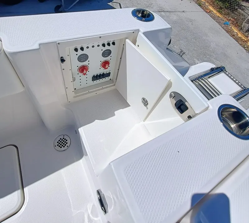 Slide: The Image of 2024 Robalo R250 Center Console boat's control panel and storage compartment. - 8