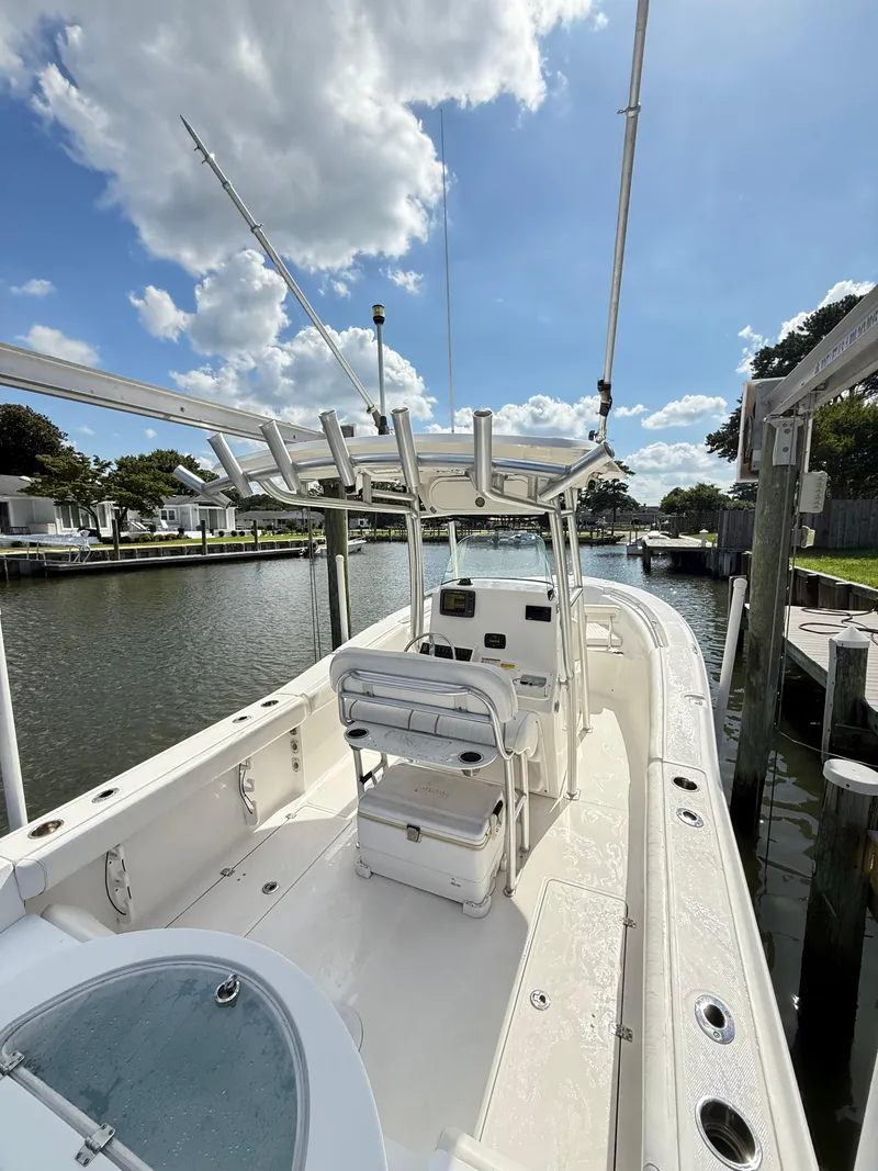 Slide: The Image of 2015 Sea Fox 256 Commander boat docked on a sunny day, showcasing spacious deck and seating. - 12