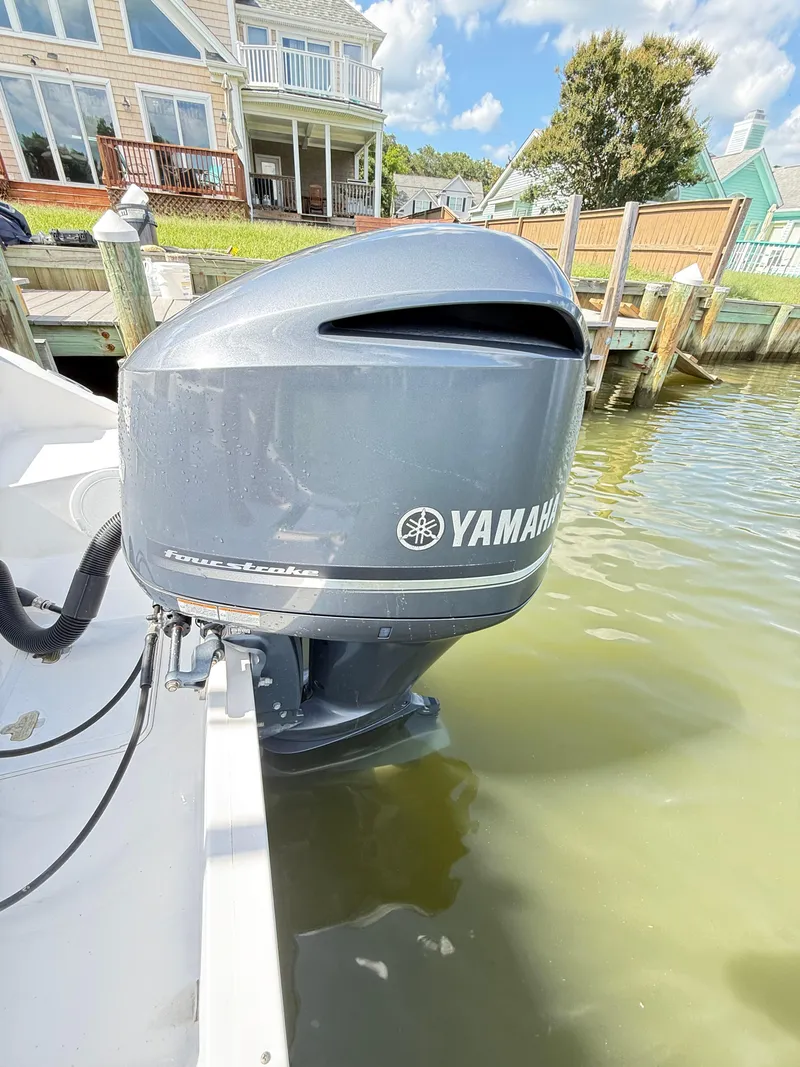 Slide: The Image of Yamaha outboard motor on a 2015 Sea Fox 256 Commander, docked by waterfront homes. - 22
