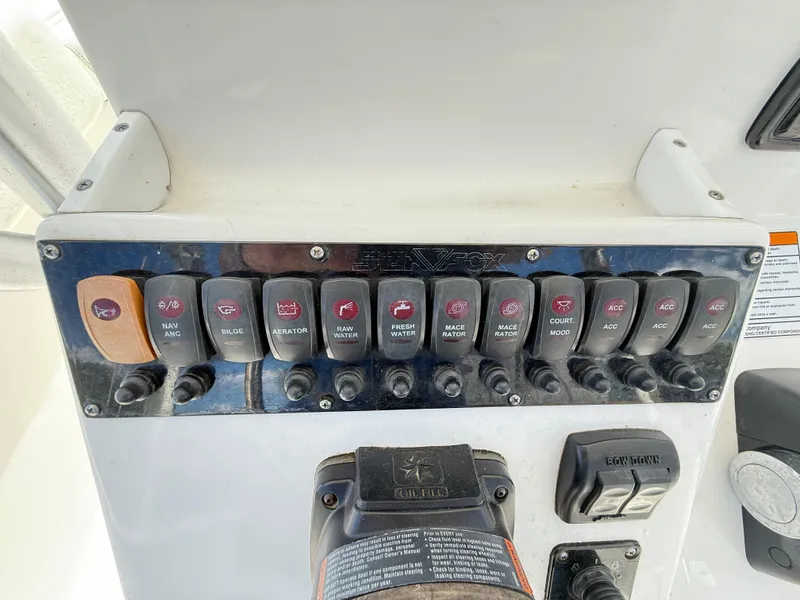 Slide: The Image of Control panel of a 2015 Sea Fox 256 Commander boat with labeled switches. - 24