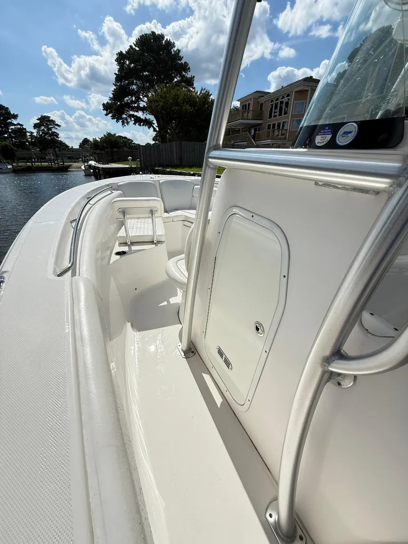 Slide: The Image of 2015 Sea Fox 256 Commander boat interior with seating and storage, docked by waterfront homes. - 28