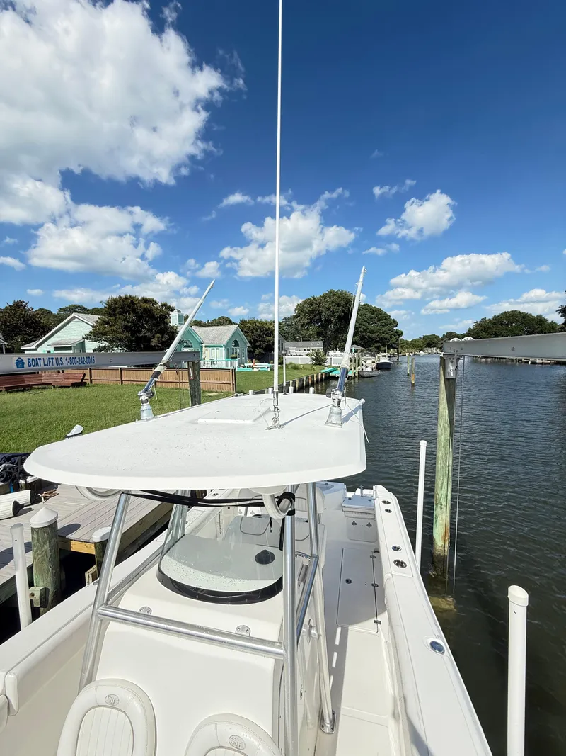 Slide: The Image of 2015 Sea Fox 256 Commander boat docked by a scenic waterfront under a clear blue sky. - 29