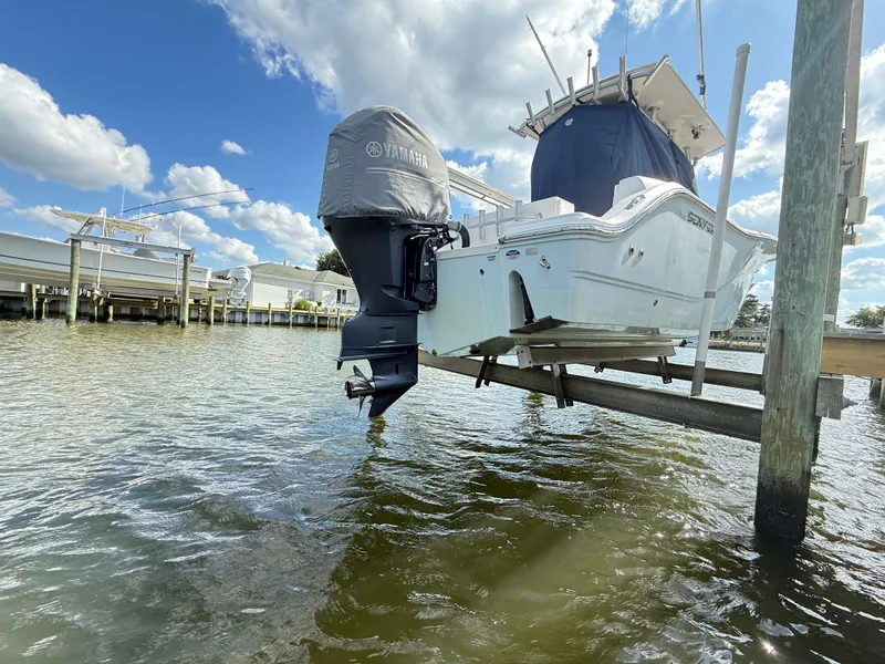 Slide: The Image of 2015 Sea Fox 256 Commander boat on lift, Yamaha engine, sunny day, waterfront view. - 33