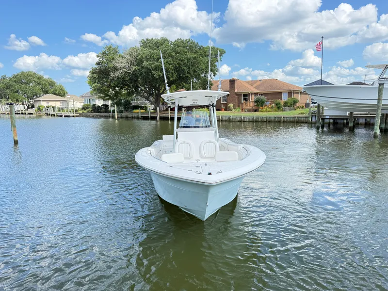 Slide: The Image of 2015 Sea Fox 256 Commander boat on calm water, with houses and trees in the background. - 5