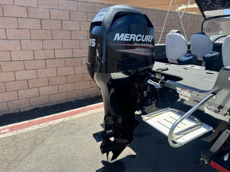 Slide: The Image of 2013 Smoker Craft Ultima 172 with Mercury 115 outboard motor, parked near a brick wall. - 6