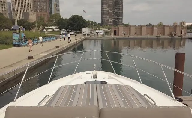 Slide: The Image of 2017 Regal 46 Sport Coupe docked in urban marina with city skyline. - 12