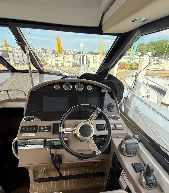 Slide: The Image of Helm of 2017 Regal 46 Sport Coupe yacht with modern controls and navigation equipment. - 17
