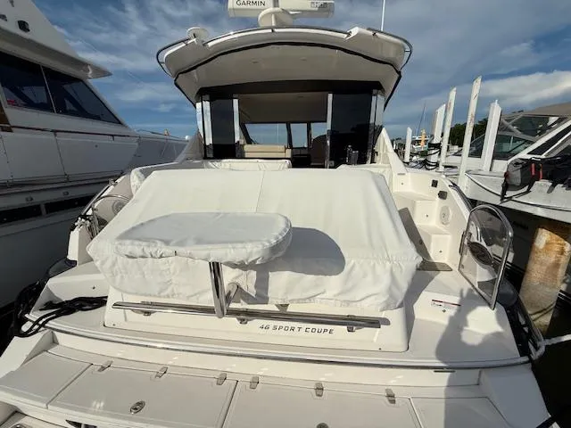 Slide: The Image of 2017 Regal 46 Sport Coupe yacht docked, featuring covered seating and modern design. - 18