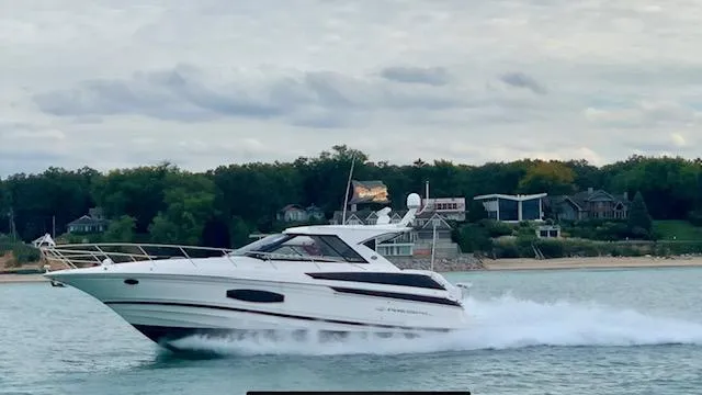 Slide: The Image of 2017 Regal 46 Sport Coupe cruising on a scenic lake with waterfront homes in the background. - 3