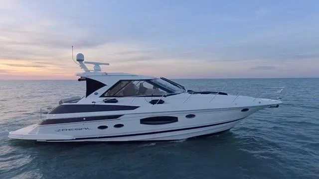 Slide: The Image of 2017 Regal 46 Sport Coupe yacht cruising on calm ocean at sunset. - 31