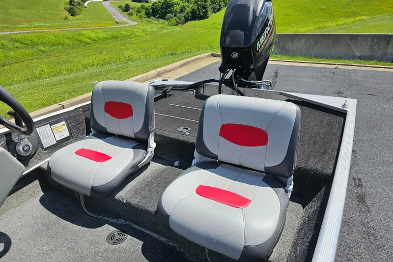 Slide: The Image of 2016 Tracker PRO160 boat interior with two gray and red seats, Mercury engine visible. - 10